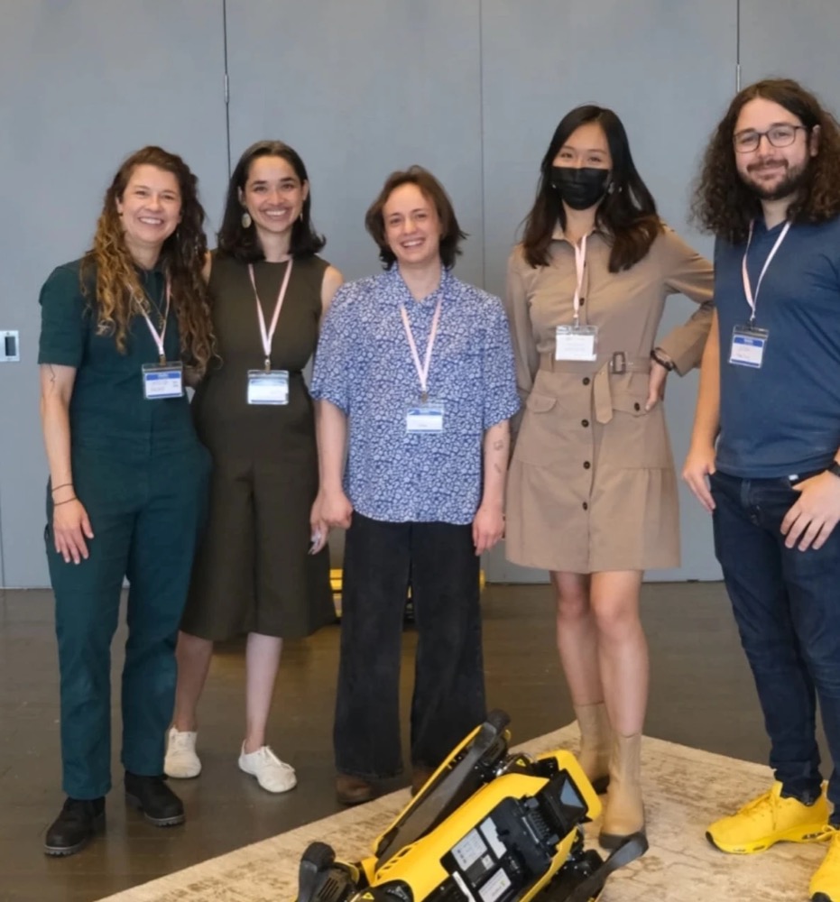 The Decoding Digital Bodies team, five people wearing conference badges, standing behind Spot
